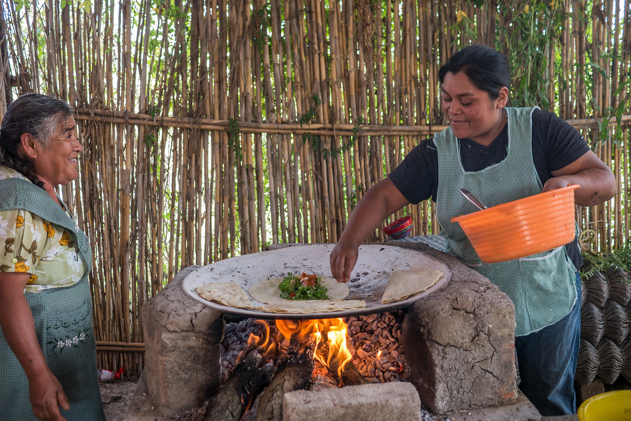 Local women in Oaxaca cooking empanadas over a fire