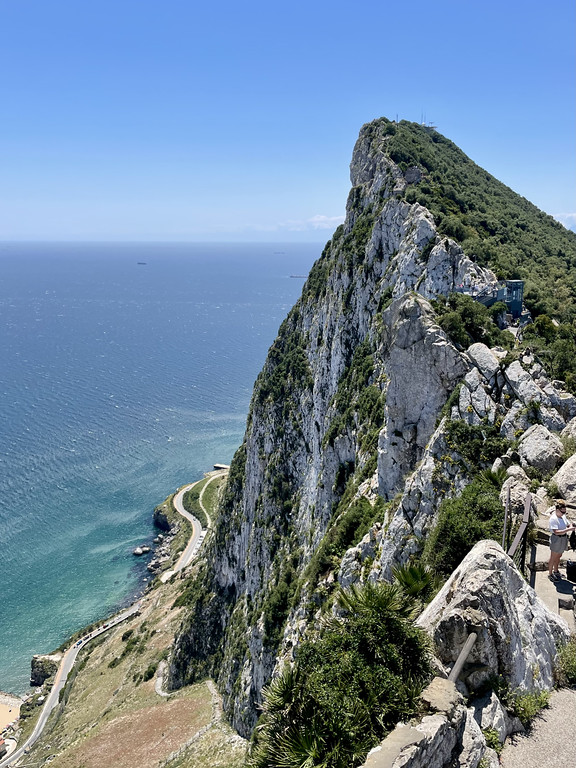 View from the Rock of Gibraltar showing a highway circling the base of the limestone peak with the sea far below.