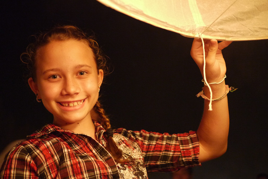 Ana does her part to light the lantern during Loy Krathong in Chiang Mai, Thailand