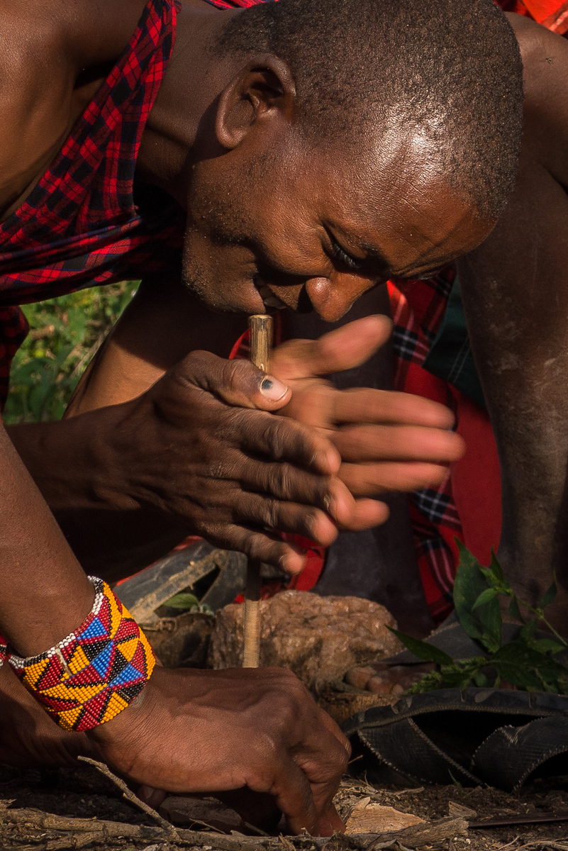 One of the Maasai warriors spins the stick quickly to create friction!