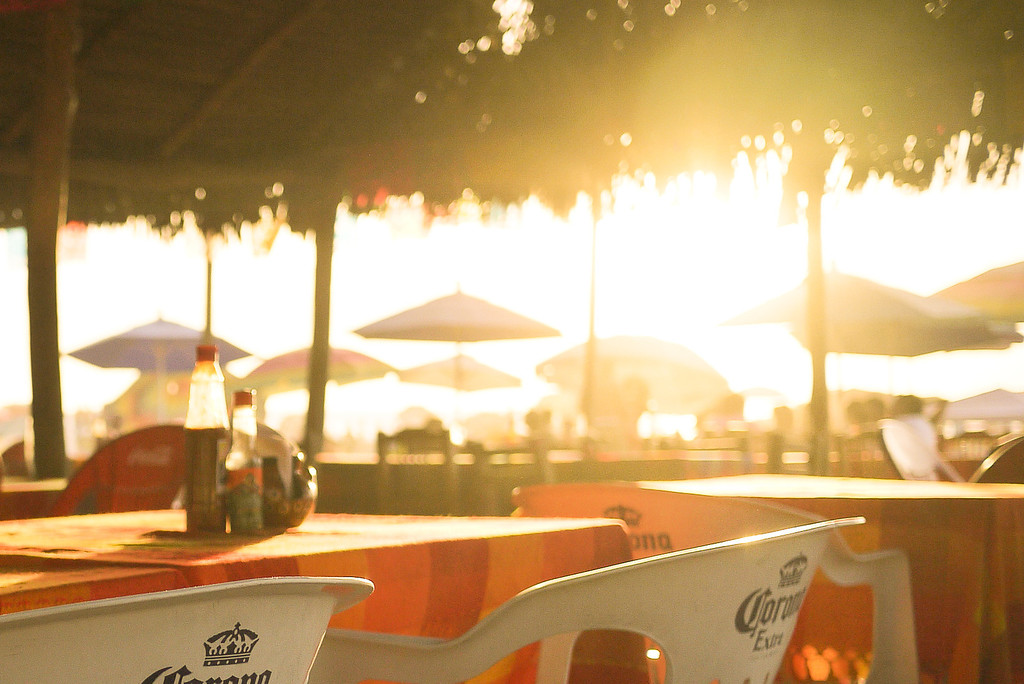Sunset through a palapa on the beach.