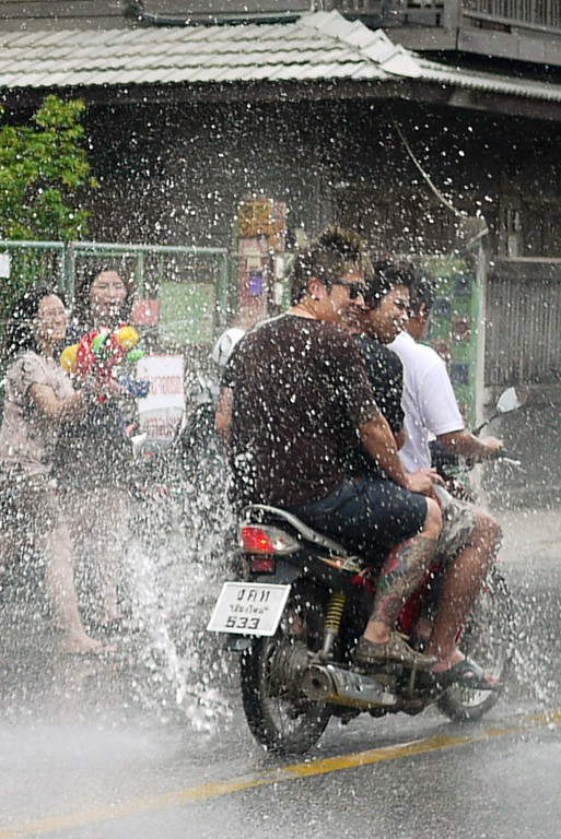 A motorbike getting nailed with water for Songkran in Chiang Mai, Thailand