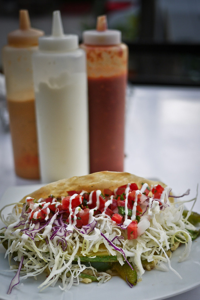 A taco with salsas and sour cream.