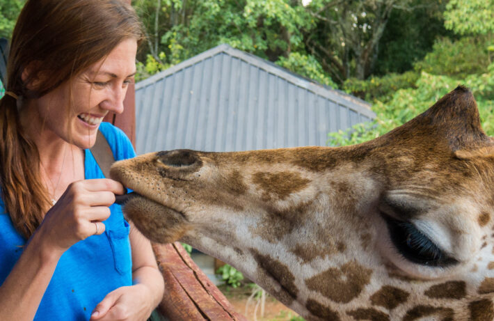 Shannon O'Donnell of A Little Adrift feeding a giraffe